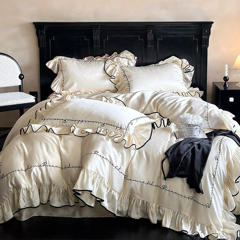 Luxurious cotton satin bedding set with ruffled flounces, contrasting piping & calligraphic embroidery
