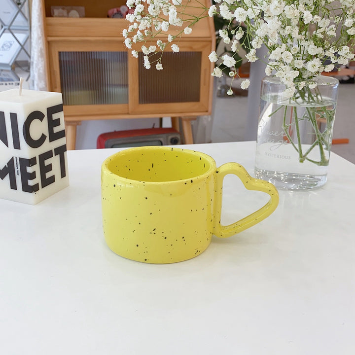 Ceramic mug with heart-shaped handle and speckle design