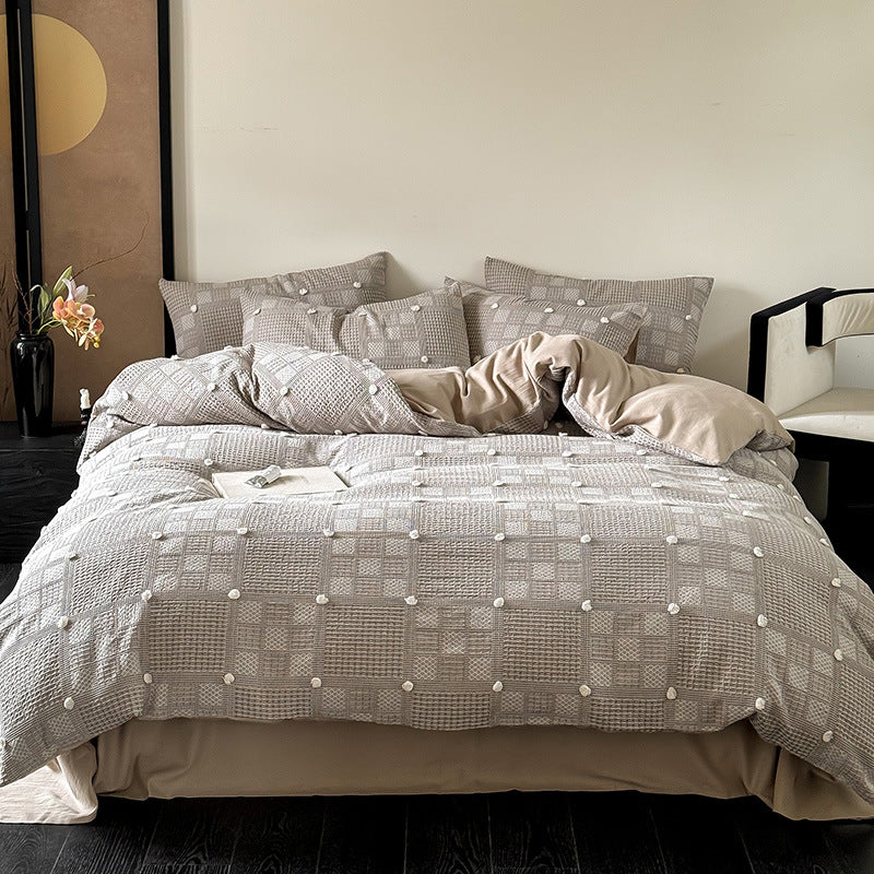 Luxurious cotton bedding set with textured waffle appearance and pompom details