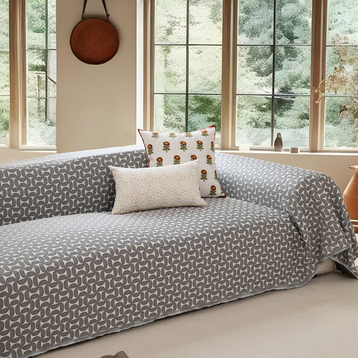 Geometric sofa cover made of cotton blend fabric with decorative fringe edge