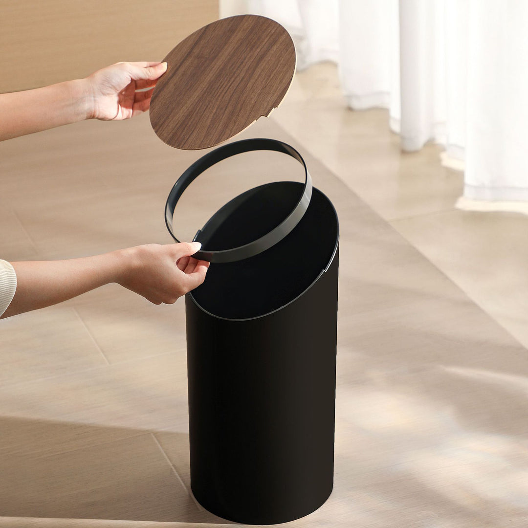 Modern oval waste bin with rotating wooden lid and noise-dampening opening