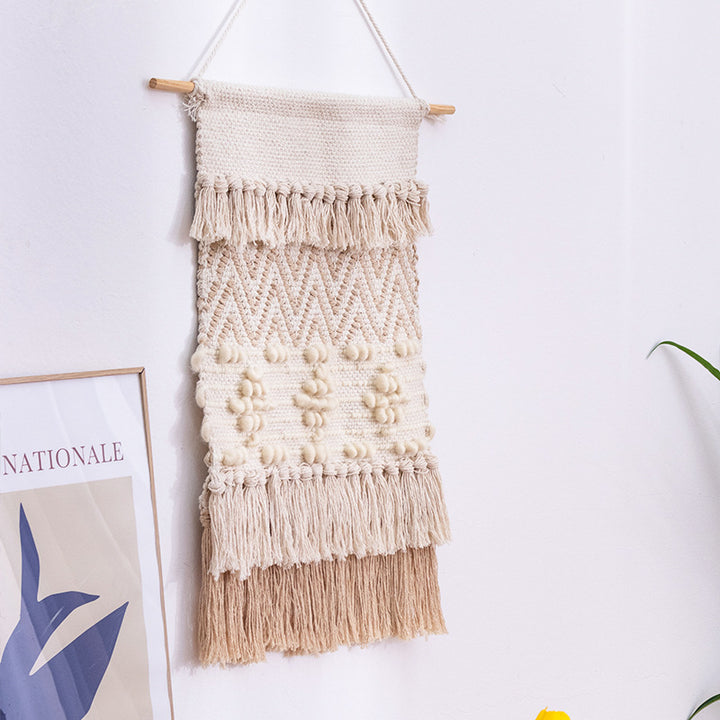 Handwoven wall hanging in boho style with tassels and geometric structure