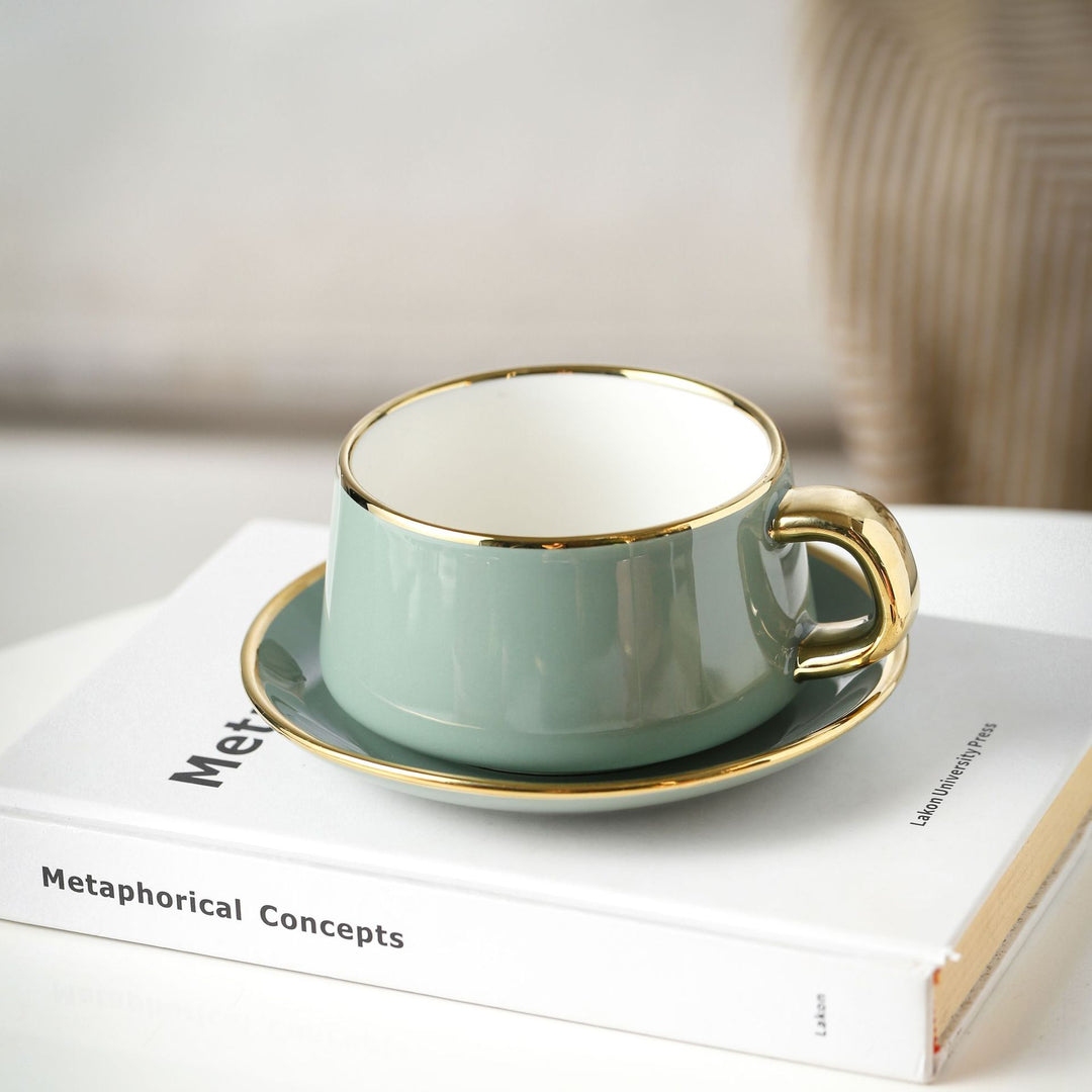 Elegant porcelain cup with saucer and sculptural gold handle