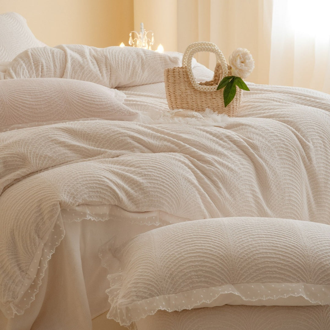 Quilted bedding set with lace edge and wave quilting pattern