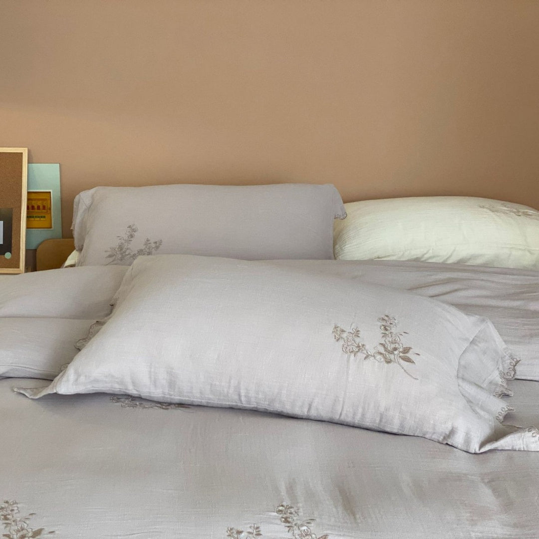 Linen look bedding set with floral embroidery and wavy hem