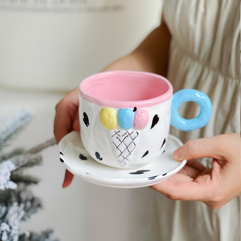 Playful handcrafted ceramic cup composition with saucer and pastel-colored round handle