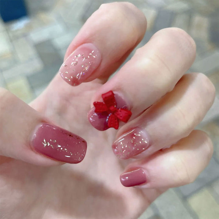 Artificial nail art with glitter embellishments and cute bow motif Kalsten