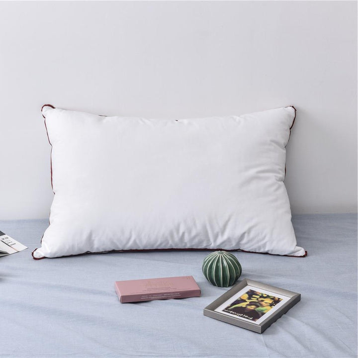 Comfort pillow with shape-stable hollow fiber filling and contrasting piping