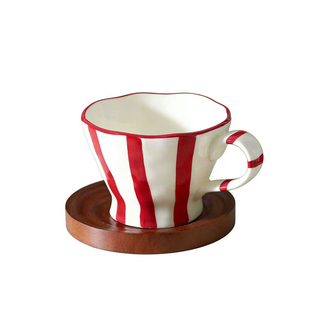 Sculptural ceramic coffee cup with curved rim and distinctive stripe decor