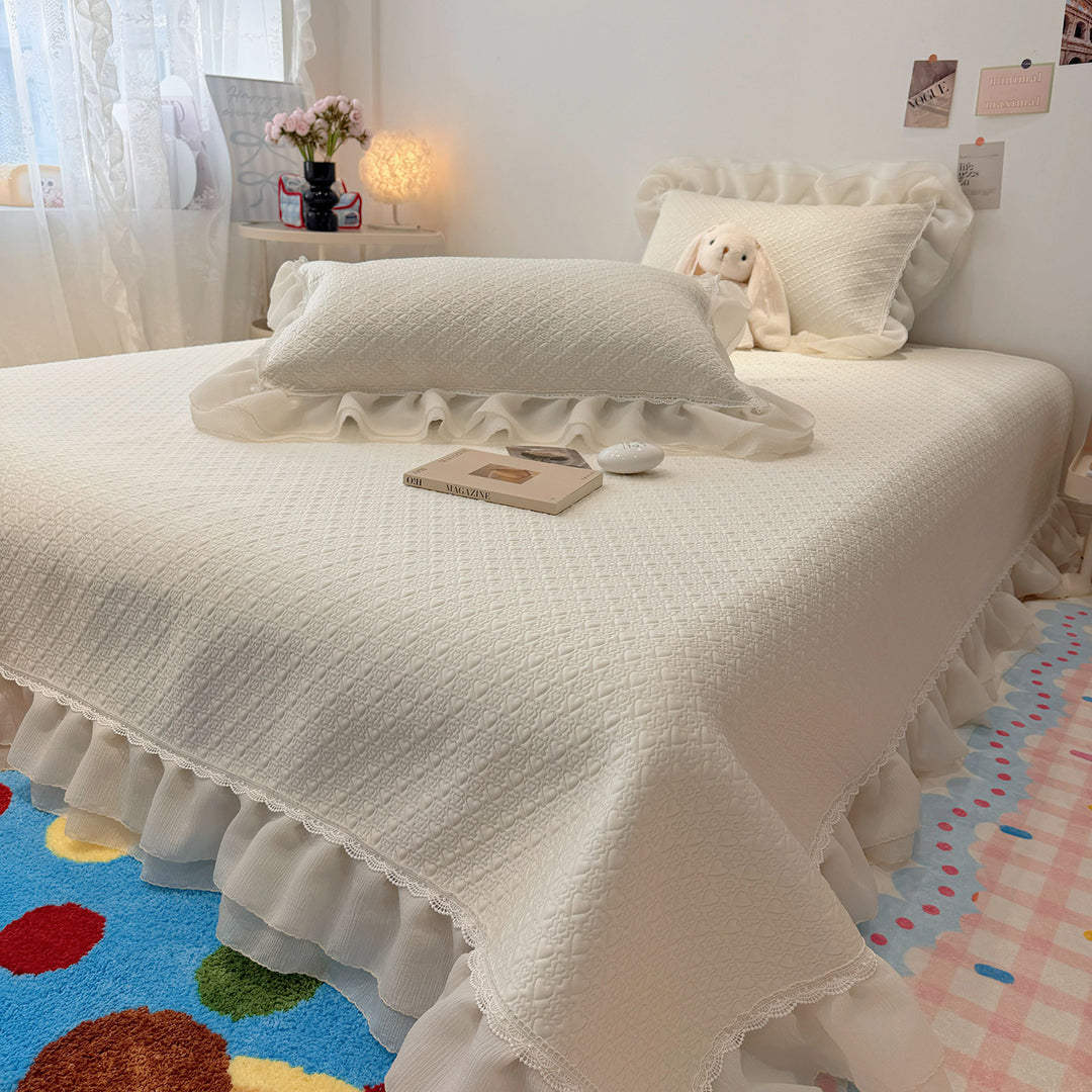 Quilted bedspread with ruffle and delicate floral quilting