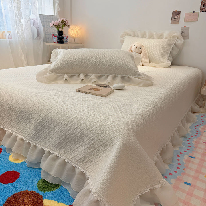 Quilted bedspread with ruffle and delicate floral quilting