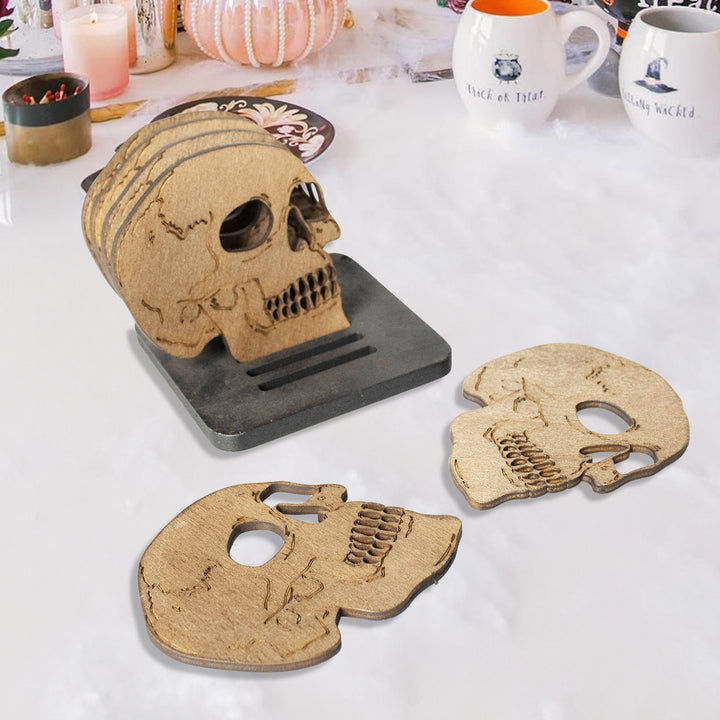 Set of laser-engraved wooden coasters in skull shape with storage stand