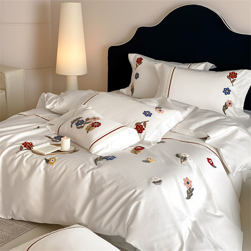 Embroidered cotton satin bedding set with floral applications and decorative border