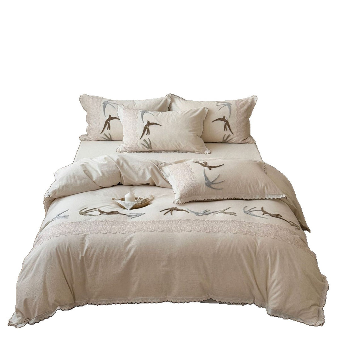 Home decor bedding set made of organic linen with hand-embroidered swallow motif and wavy hem