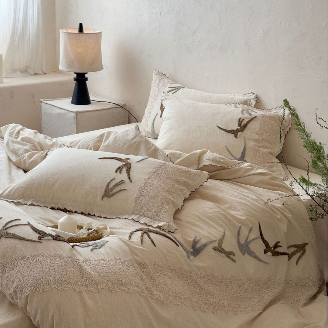 Home decor bedding set made of organic linen with hand-embroidered swallow motif and wavy hem