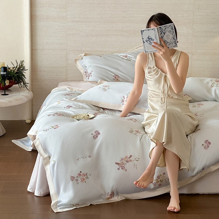 Fine satin duvet cover set with delicate floral embroidery and elegant piping