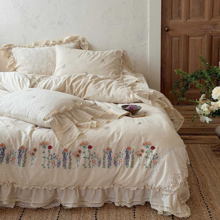 Romantic linen-cotton bedding set with embroidered floral border and ruffle