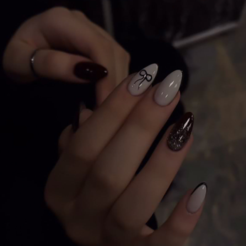 Artful nail art with elegant bow pattern and glitter accents Kalsten
