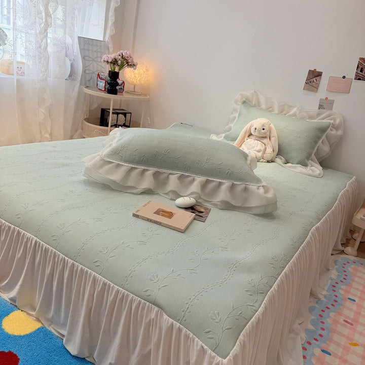 Quilted bedspread with ruffle and delicate floral quilting