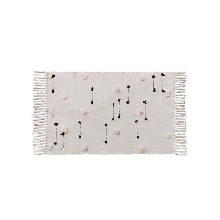 Hand-tufted bathroom mat with fringes, decorative dot-and-dash pattern and non-slip backing Kalsten