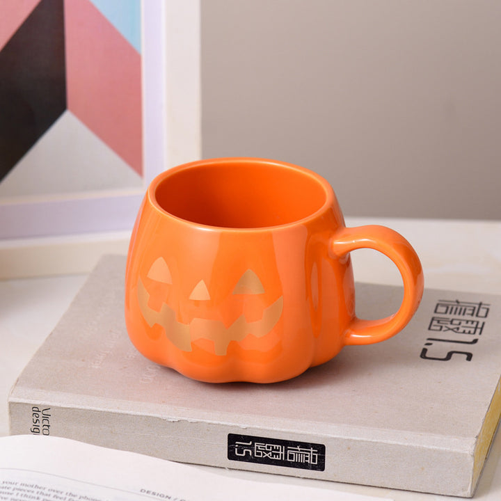 Ceramic mug in pumpkin shape with handle and carved face