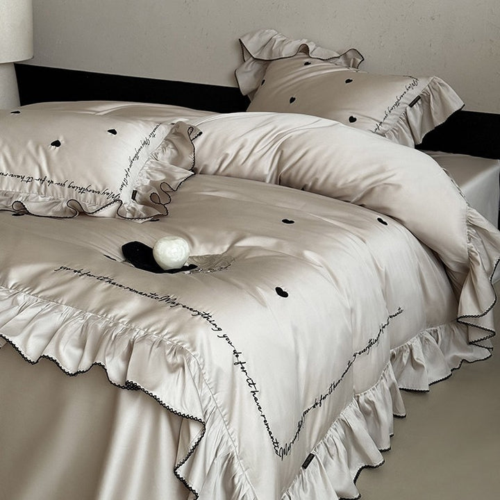 Luxurious cotton satin bedding set with ruffled trim, embroidered heart motifs, and calligraphic writing