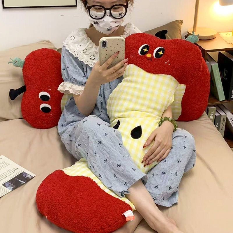 Extra-long ergonomic cuddle body pillow in apple core design with gingham cover and soft plush ends