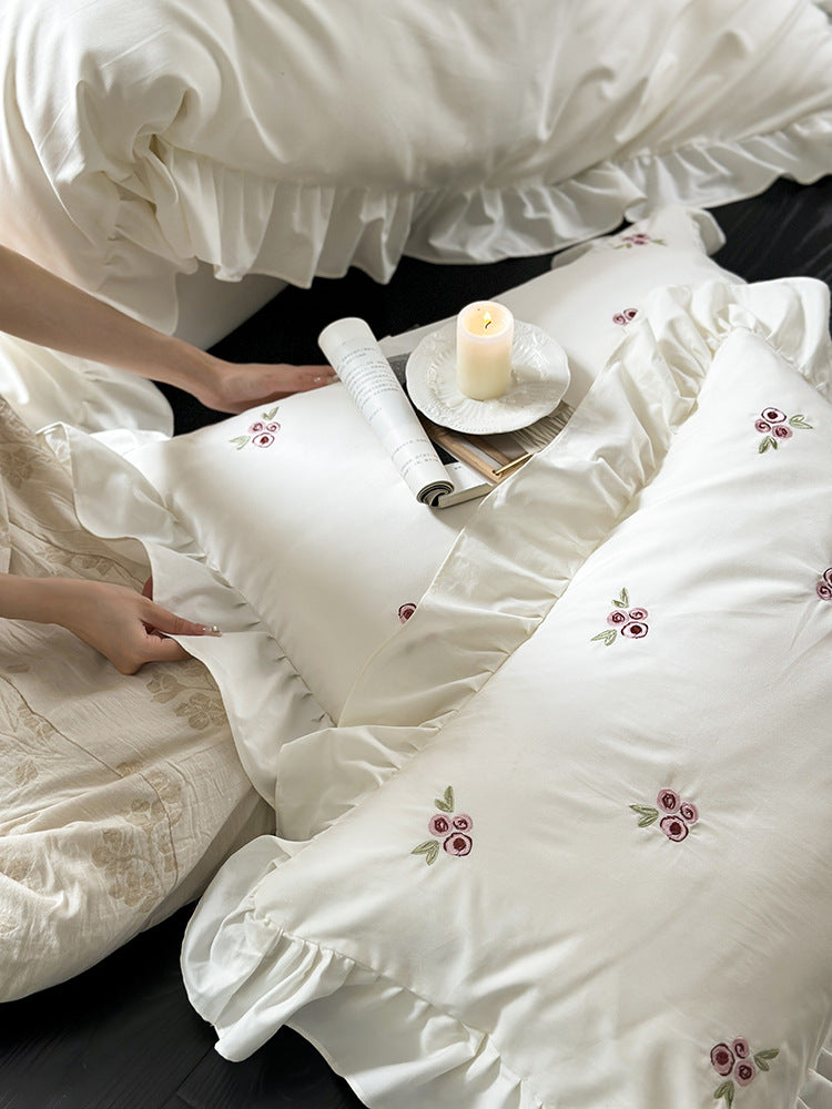 Elegant bed linen set made of breathable cotton satin with delicate floral embroidery and ruffled hem