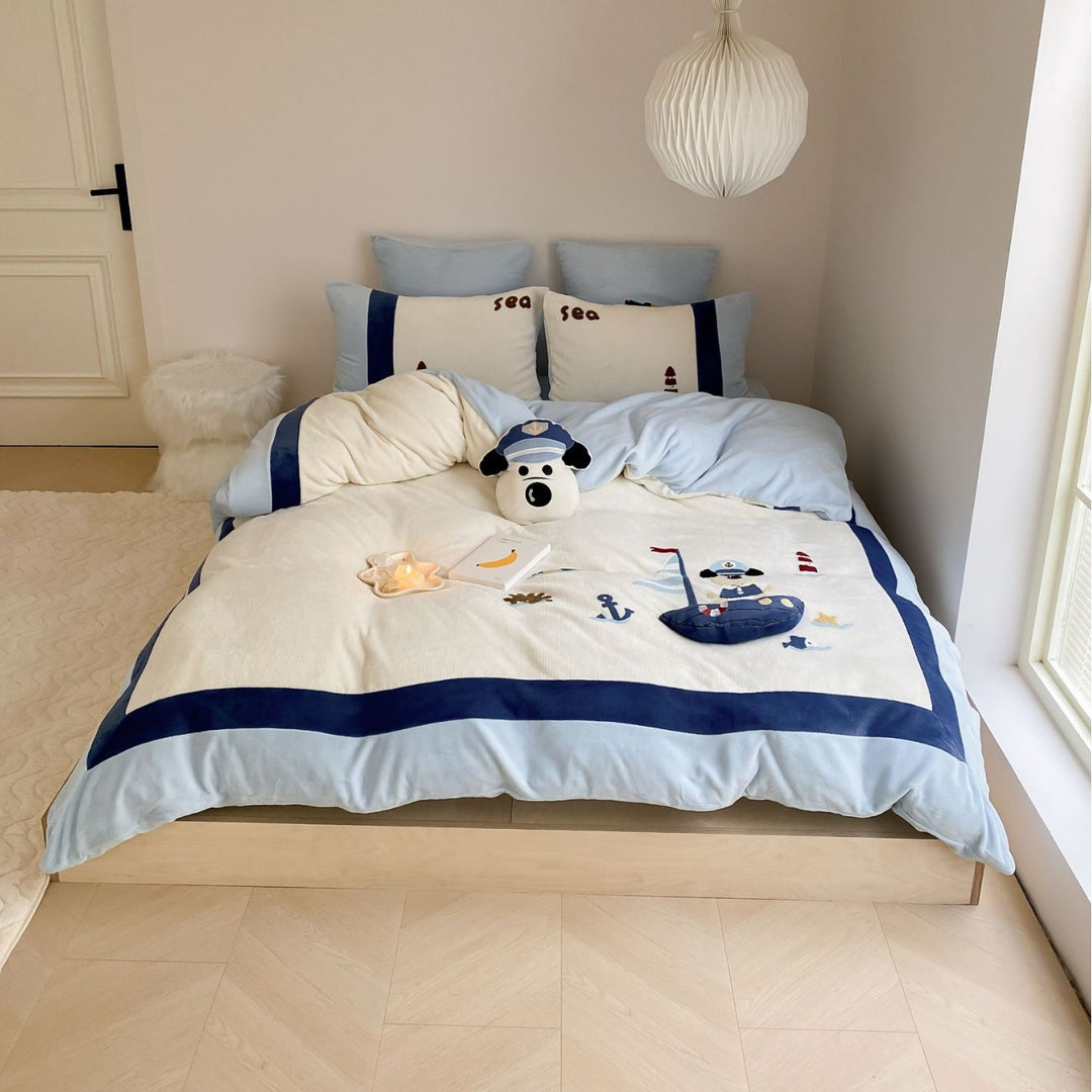 Cozy bedding set with plush border, embroidered appliqués, and reversible function
