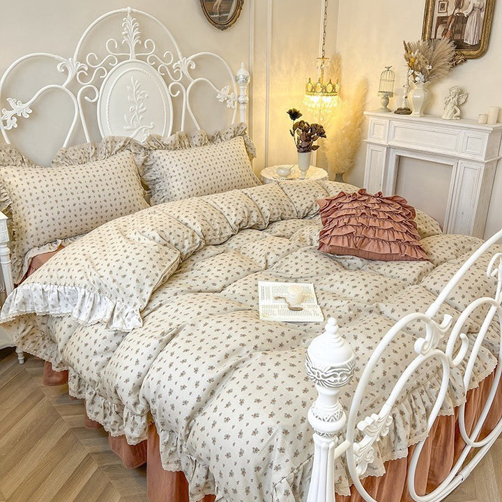 Romantic quilted comforter with ruffled border and fine floral pattern