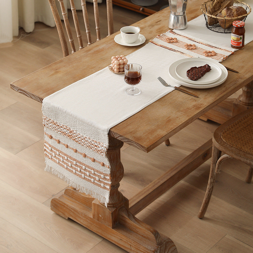 Woven cotton table runner with textured tufting and fringed border