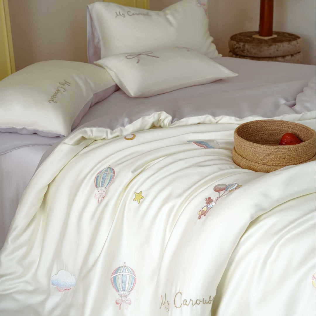 Premium children's bedding set made of cotton satin with pastel-embroidered balloon and carousel motifs.
