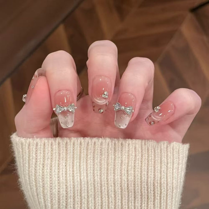 Art nails with delicate rhinestone and bow accents Kalsten