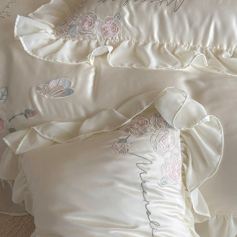 Luxurious satin bed linen set with relief-embroidered rose appliqués and ruffles