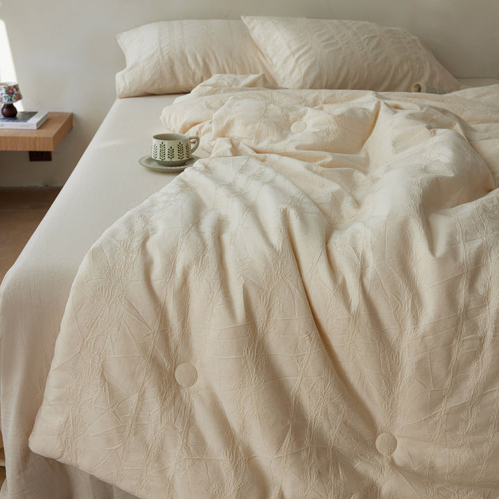 Quilted duvet cover made of linen-cotton mix with subtle textured embroidery and button tufting