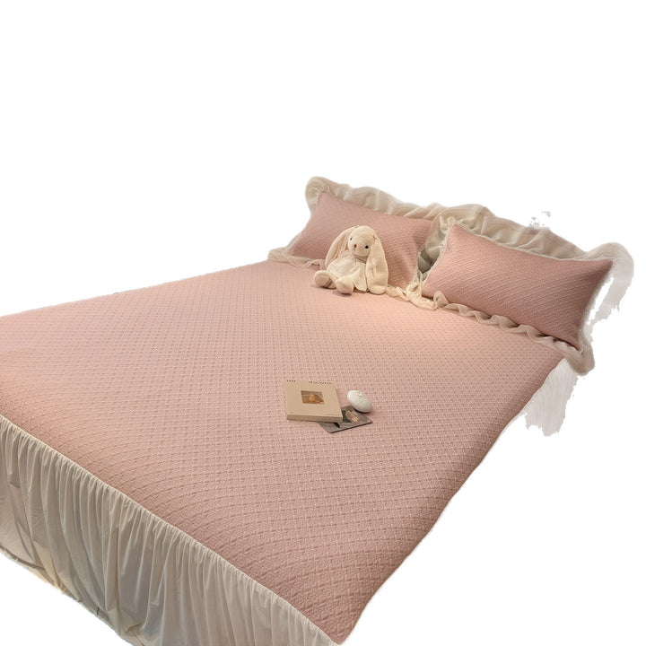 Quilted bedspread with ruffle and delicate floral quilting