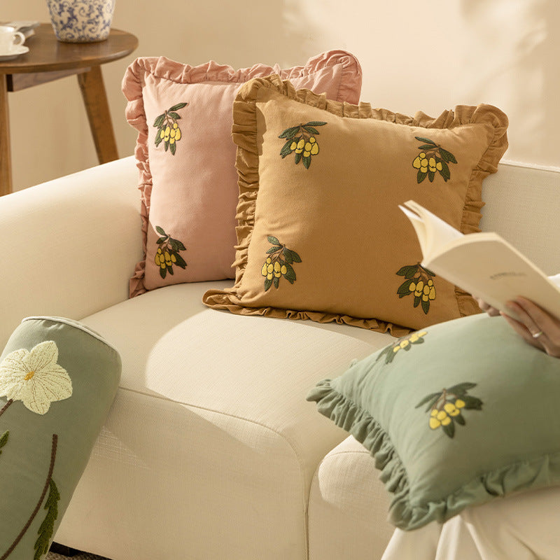 Square decorative pillow with ruffled edges and hand-stitched flower appliqués