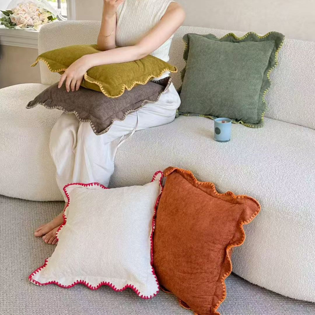 Decorative velvet cushion with wavy edge and decorative stitching