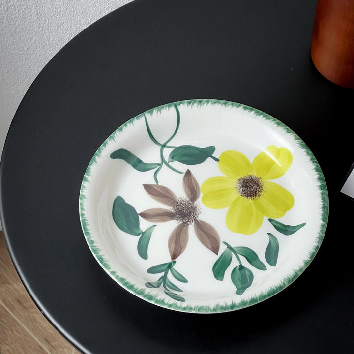 Deep porcelain plate with floral rim ornamentation and contrasting inner mirror