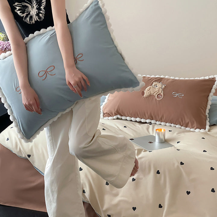 Children's bed set with teddy bear embroidery, pom-pom edging, and reversible blanket