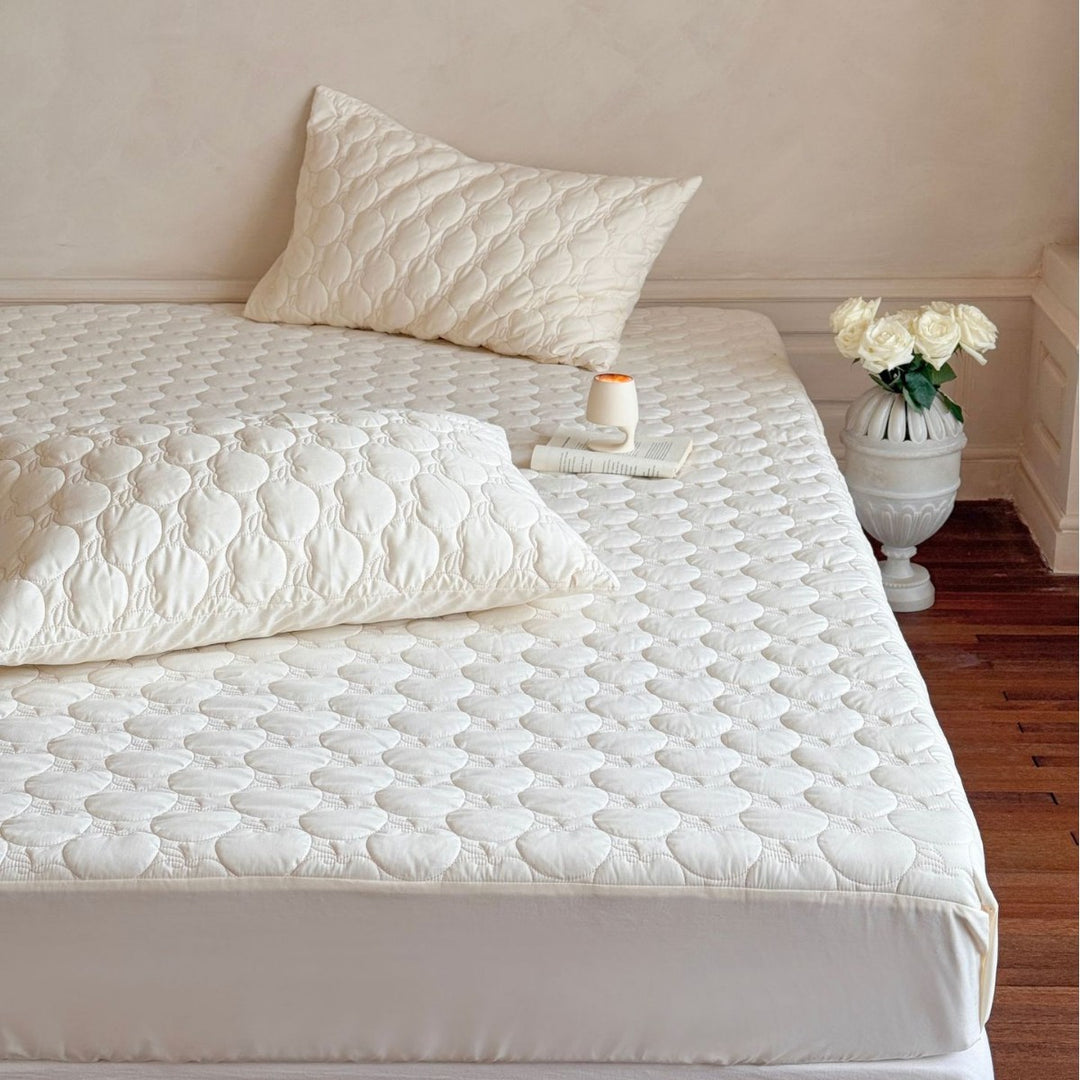 Padded mattress protector with quilted comfort layer and all-around elastic band