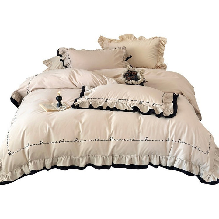 Luxurious cotton satin bedding set with ruffle, contrasting piped trim, and calligraphic embroidery