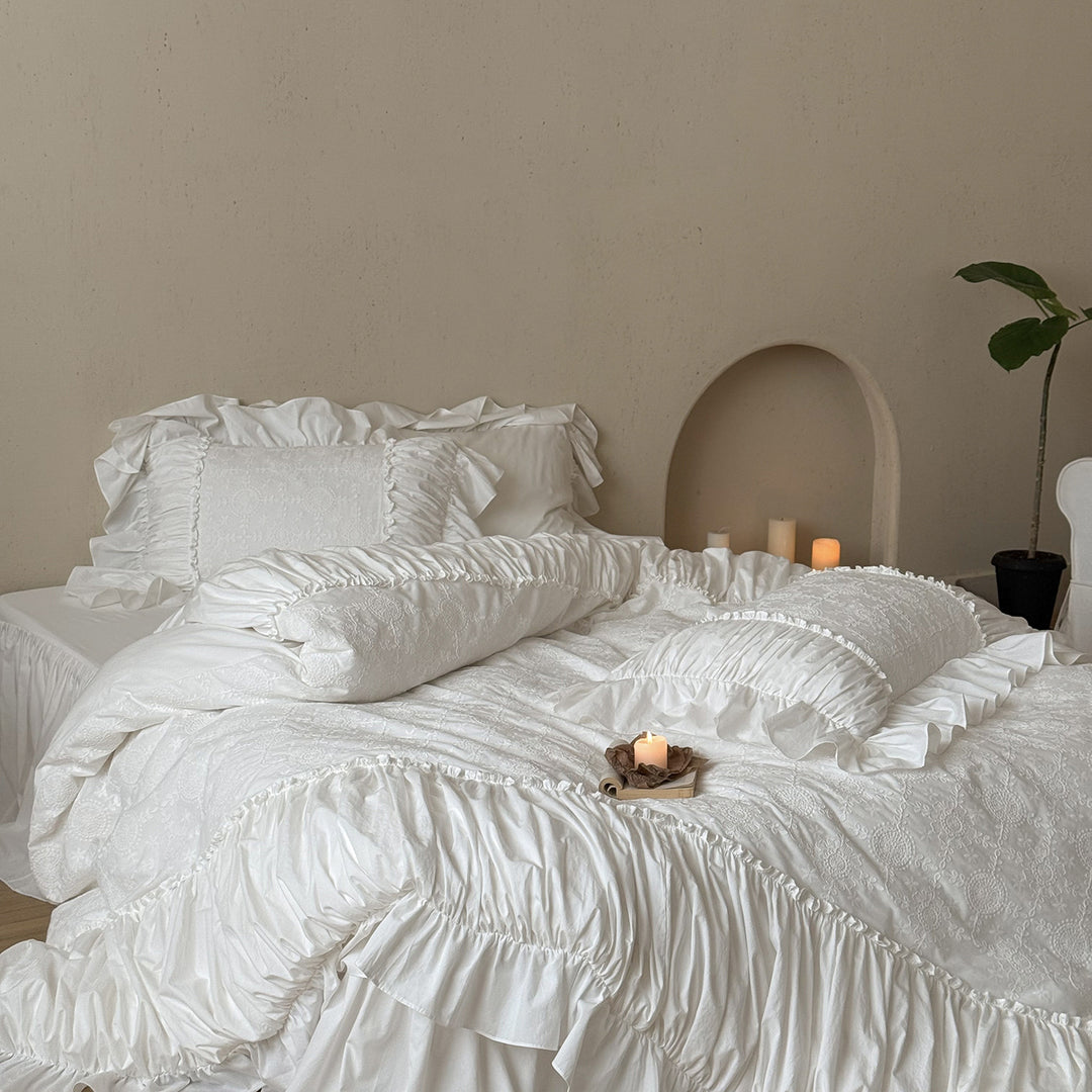 Romantic broderie anglaise bedding set with ruffle, quilted bedspread and decorative cushion