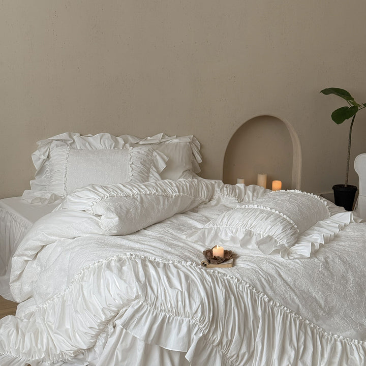 Romantic broderie anglaise bedding set with ruffle, quilted bedspread and decorative cushion