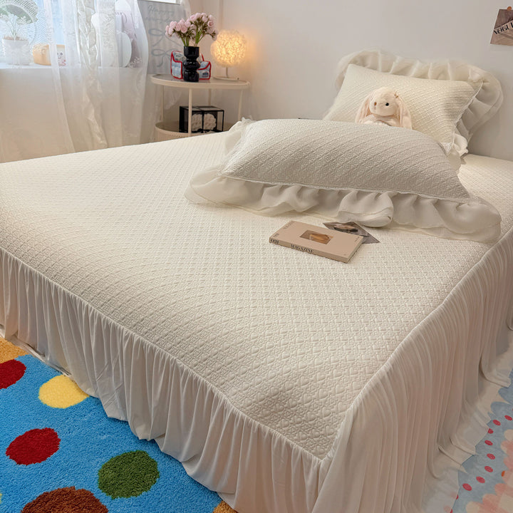 Quilted bedspread with ruffle and delicate floral quilting