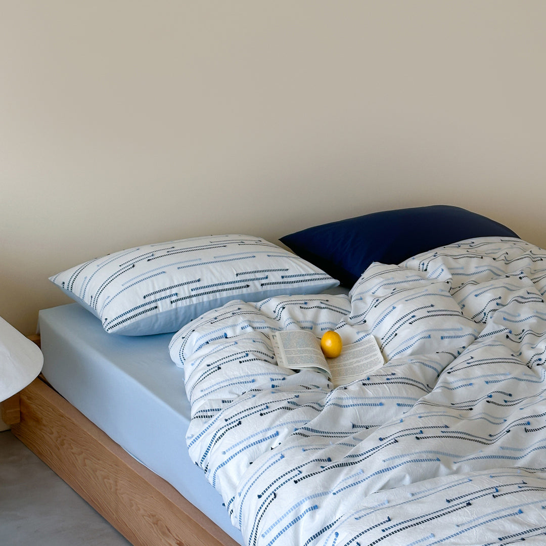 Bedding set made of cotton percale with subtle stripe and pompom design