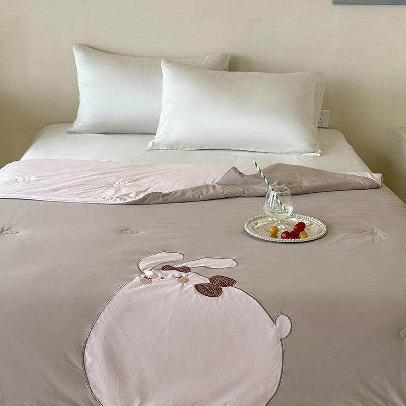 Reversible quilted bedspread with embroidered bear motif and light filling