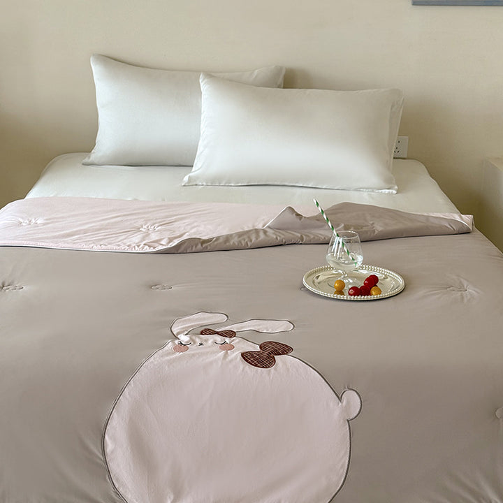 Reversible quilted bedspread with embroidered bear motif and light filling