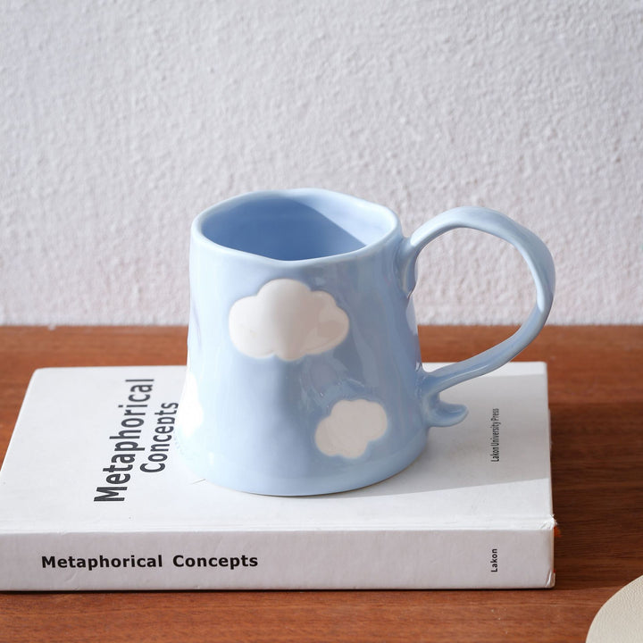 Hand-shaped ceramic mug with cloud relief and organic edge