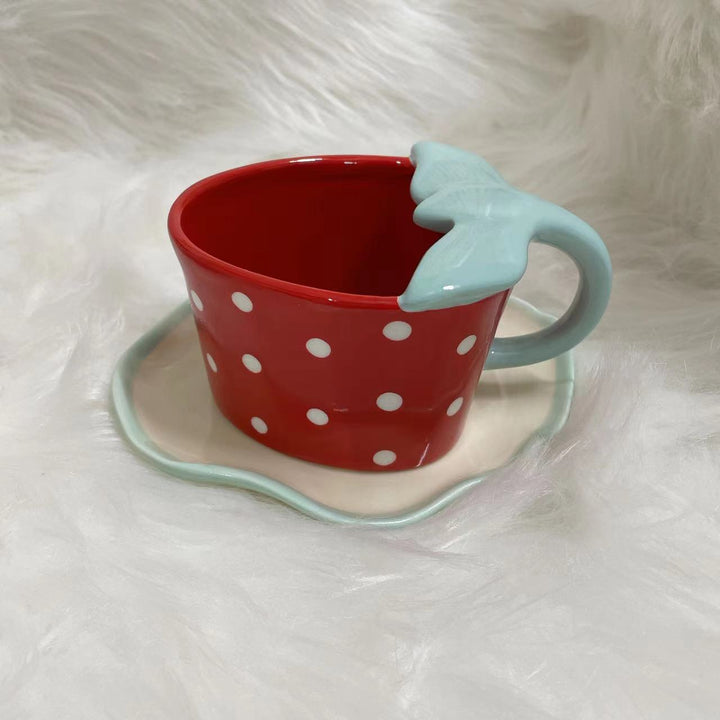 Playful ceramic mug with shaped leaf handle, saucer, and tulip spoon